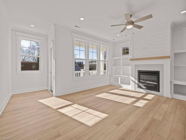 unfurnished living room with ornamental molding, built in features, ceiling fan, and light hardwood / wood-style flooring