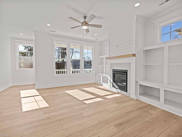 unfurnished living room featuring ornamental molding, ceiling fan, light wood-type flooring, and built in shelves