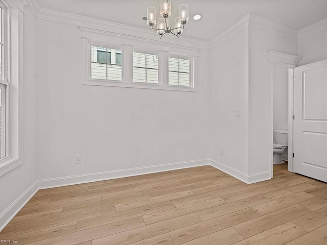 empty room featuring crown molding, a chandelier, and light hardwood / wood-style flooring