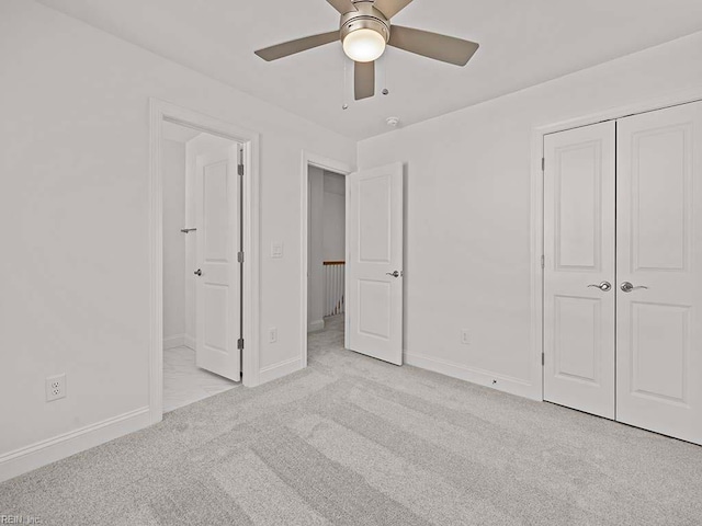 unfurnished bedroom with light colored carpet, a closet, and ceiling fan