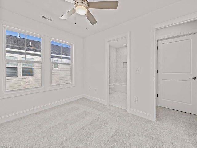 unfurnished bedroom featuring light carpet, ensuite bath, and ceiling fan