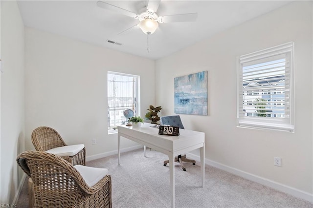 carpeted office with ceiling fan and a healthy amount of sunlight