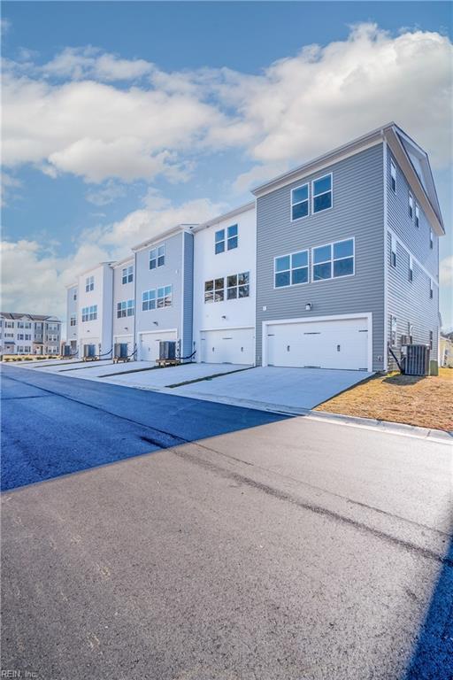 view of front of house with a garage and central air condition unit