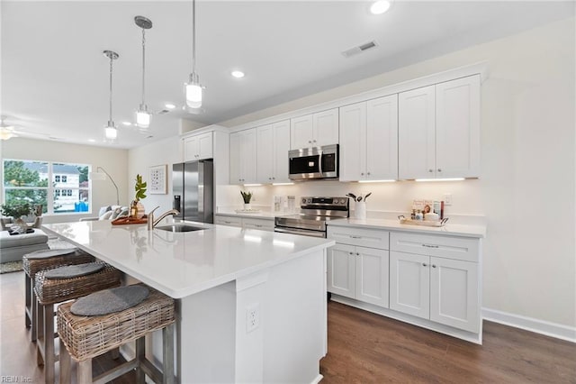 kitchen featuring white cabinetry, appliances with stainless steel finishes, and a center island with sink