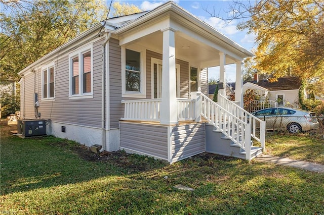 view of home's exterior featuring a porch, central AC unit, and a lawn