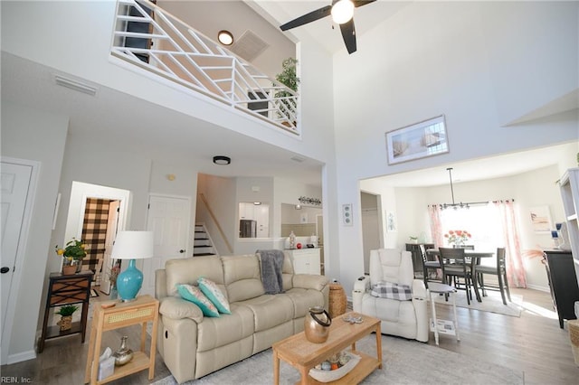 living room featuring hardwood / wood-style flooring, ceiling fan, and a high ceiling