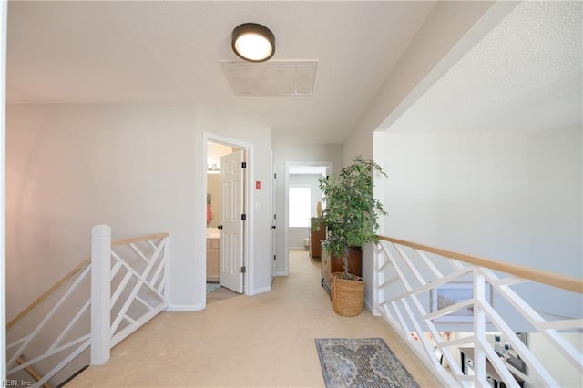 hall featuring light colored carpet