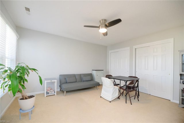 office space with ceiling fan and light carpet