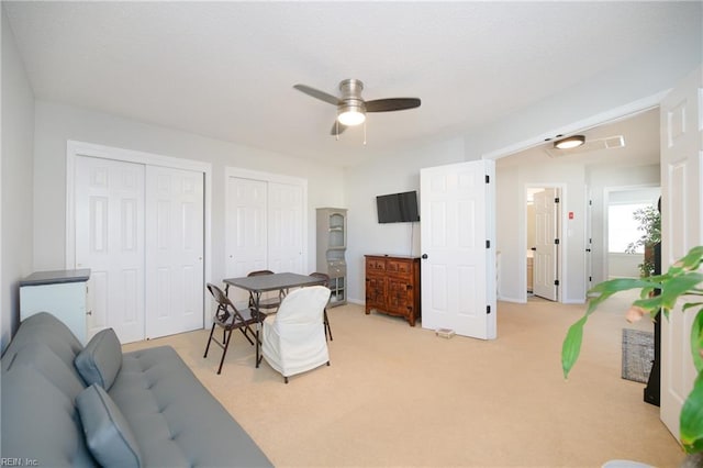 interior space featuring ceiling fan and light colored carpet