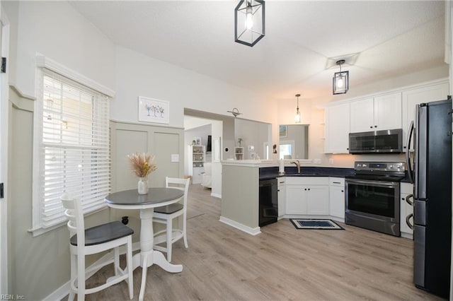 kitchen featuring white cabinetry, decorative light fixtures, light wood-type flooring, appliances with stainless steel finishes, and kitchen peninsula