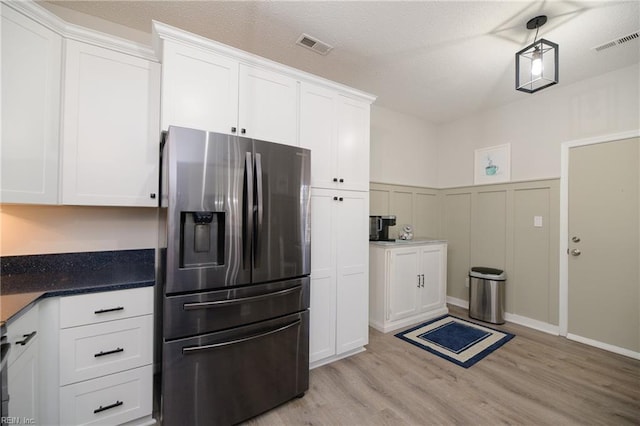 kitchen with white cabinets, stainless steel fridge, and light wood-type flooring