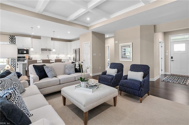 living room featuring coffered ceiling, sink, beam ceiling, and light hardwood / wood-style floors