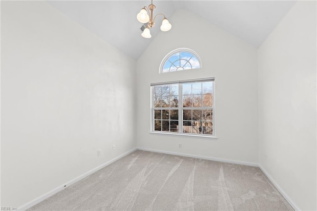 carpeted empty room featuring an inviting chandelier and high vaulted ceiling