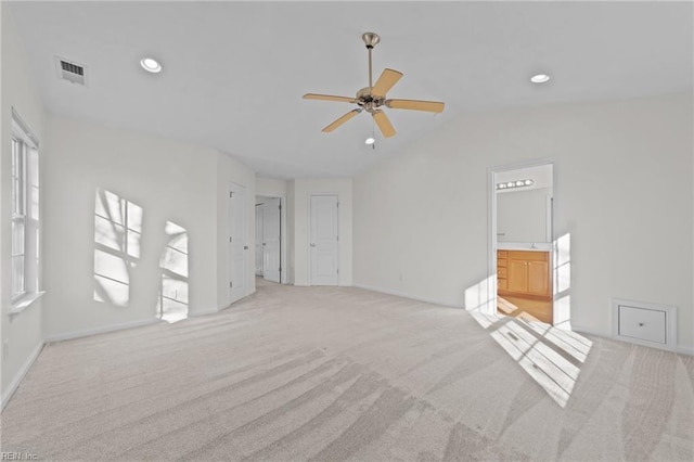 unfurnished living room featuring vaulted ceiling, light colored carpet, and ceiling fan