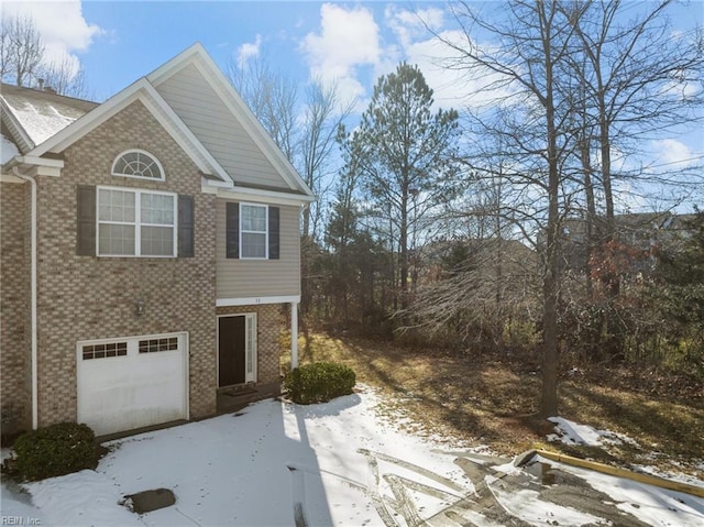 view of snowy exterior featuring a garage