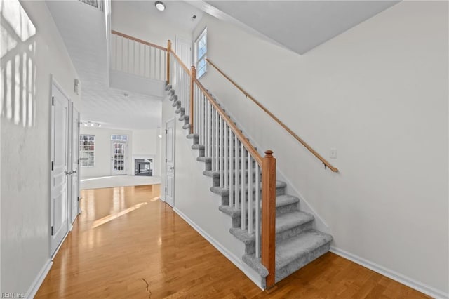 staircase with hardwood / wood-style flooring and a high ceiling