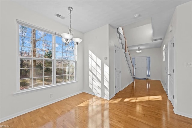 foyer featuring wood-type flooring and a notable chandelier