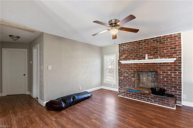 unfurnished living room featuring ceiling fan, a textured ceiling, a fireplace, and dark hardwood / wood-style flooring