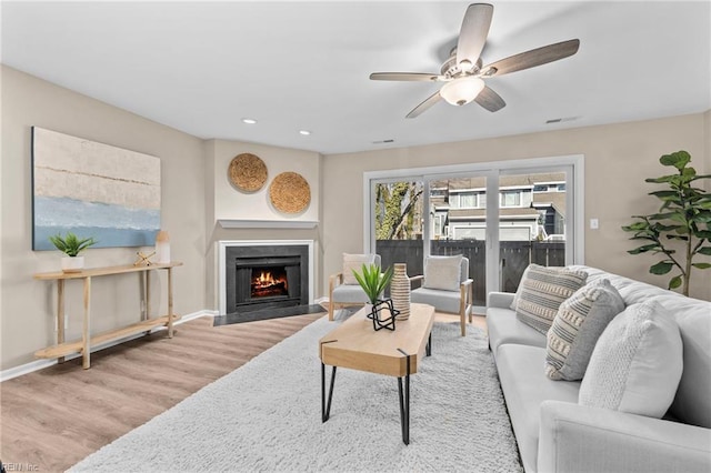 living room with ceiling fan and light wood-type flooring