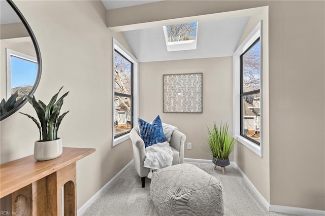 living area featuring plenty of natural light, lofted ceiling with skylight, and carpet