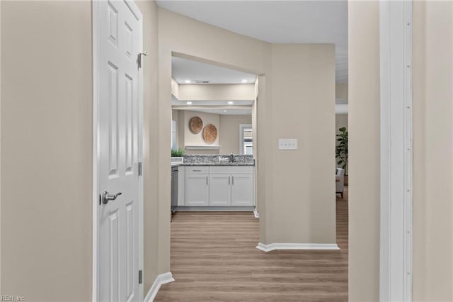 hall with sink and light hardwood / wood-style floors