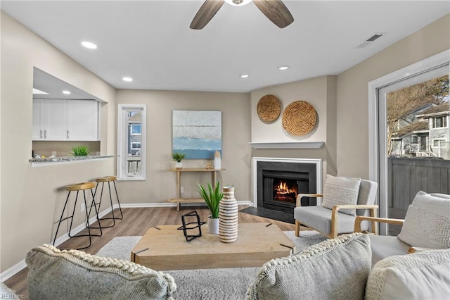 living room with light hardwood / wood-style flooring and ceiling fan