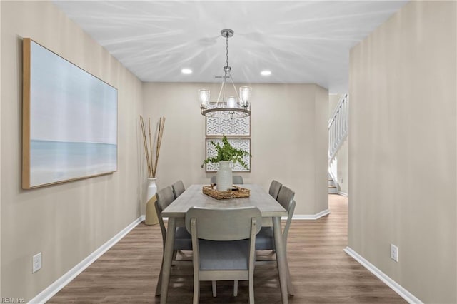 dining space with dark wood-type flooring and a chandelier