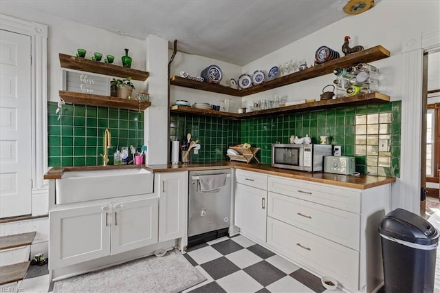 kitchen with sink, decorative backsplash, white cabinets, and appliances with stainless steel finishes