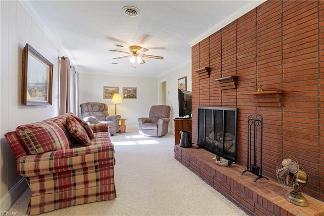 carpeted living room with crown molding, a brick fireplace, and ceiling fan