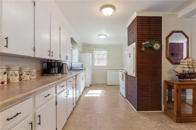 kitchen featuring white appliances, ornamental molding, white cabinets, and light tile patterned flooring