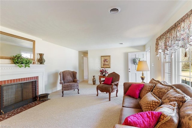 living room featuring light colored carpet, a brick fireplace, and a wealth of natural light