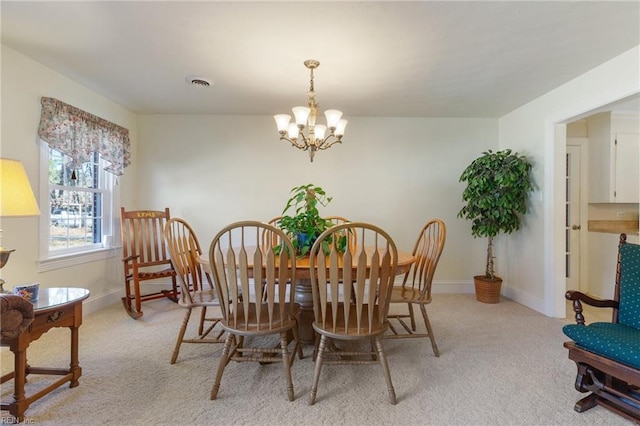 dining room featuring light carpet and a notable chandelier