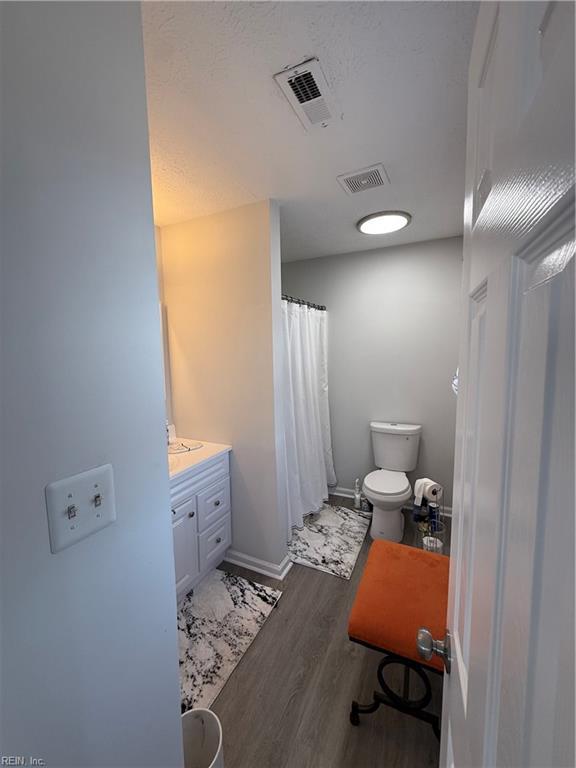 bathroom with vanity, hardwood / wood-style floors, and toilet