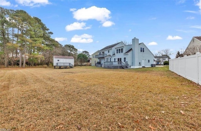 view of yard featuring a wooden deck and a storage shed