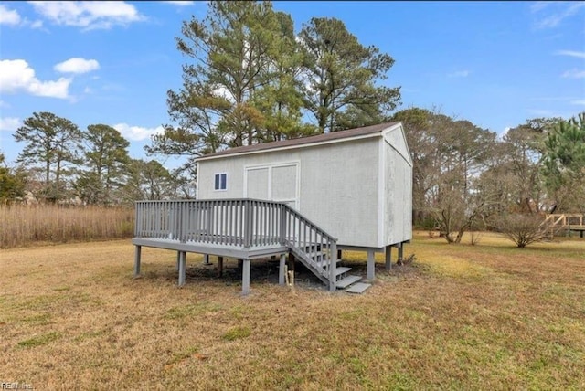 rear view of house featuring a deck and a lawn