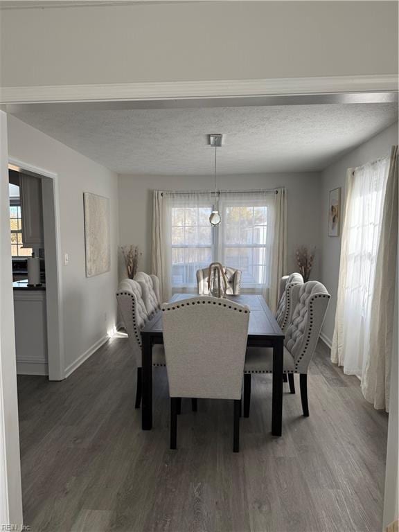 dining space with a textured ceiling and dark hardwood / wood-style flooring