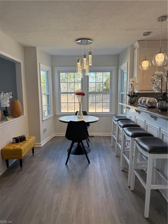 dining area with dark hardwood / wood-style flooring and a textured ceiling