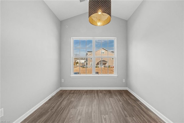 empty room featuring vaulted ceiling and dark wood-type flooring