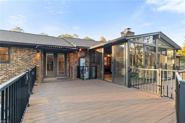 wooden terrace featuring french doors and a sunroom