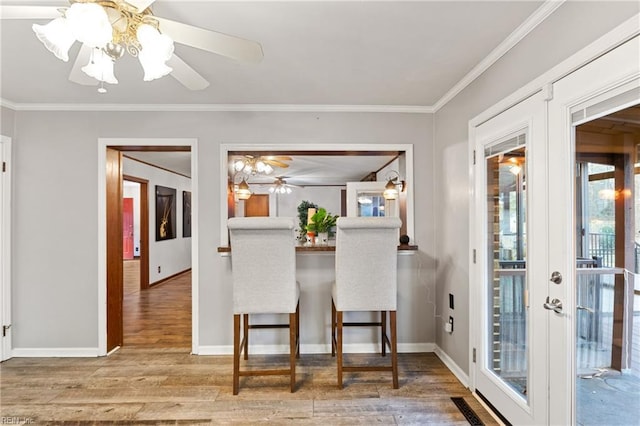 dining room with hardwood / wood-style flooring, ornamental molding, ceiling fan, and french doors