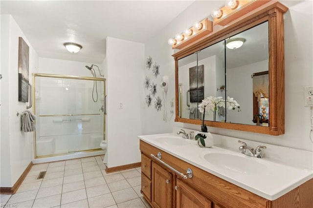 bathroom with vanity, toilet, tile patterned flooring, and a shower with door