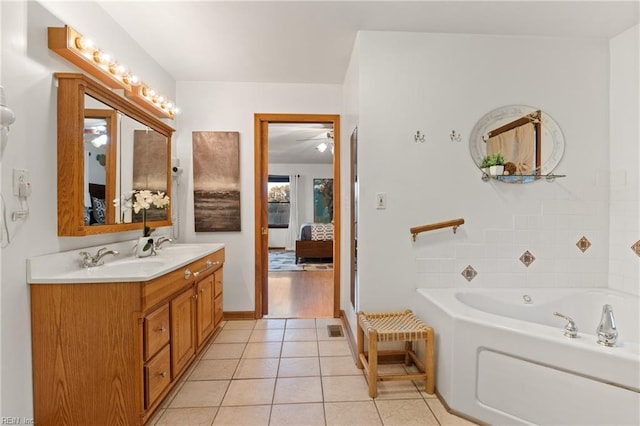 bathroom featuring tile patterned flooring, a tub to relax in, and vanity