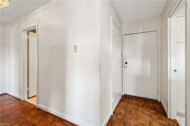 corridor featuring dark parquet flooring