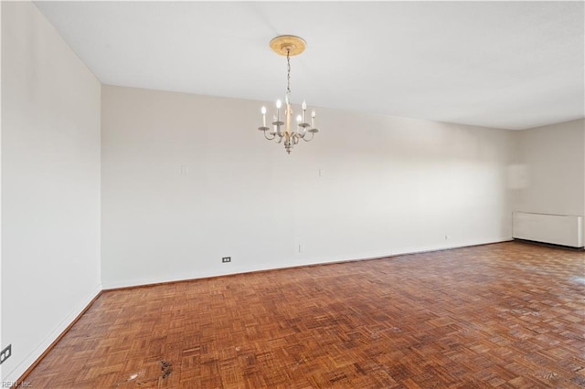 spare room with parquet floors and a chandelier