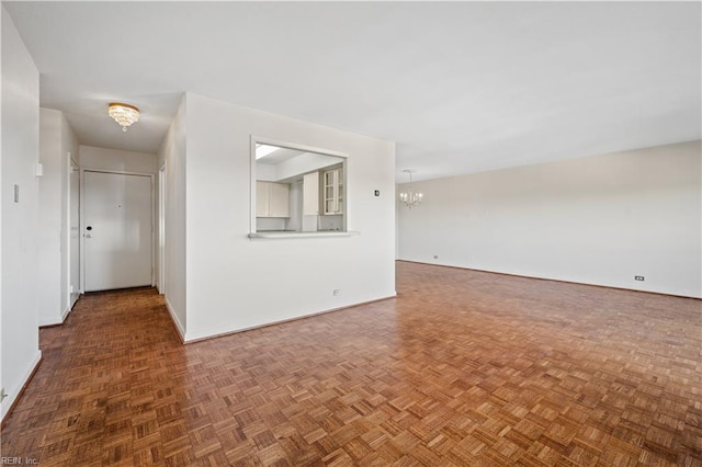 unfurnished room featuring an inviting chandelier and parquet floors