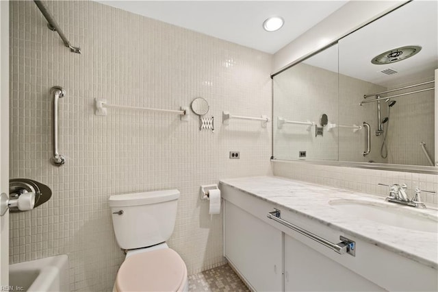 bathroom with vanity, tile walls, and toilet