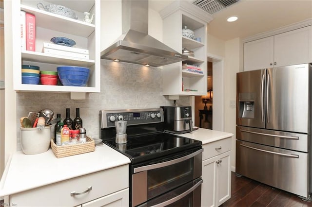 kitchen with appliances with stainless steel finishes, island range hood, tasteful backsplash, white cabinets, and dark wood-type flooring