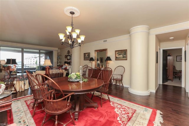 dining space featuring decorative columns, dark wood-type flooring, and an inviting chandelier