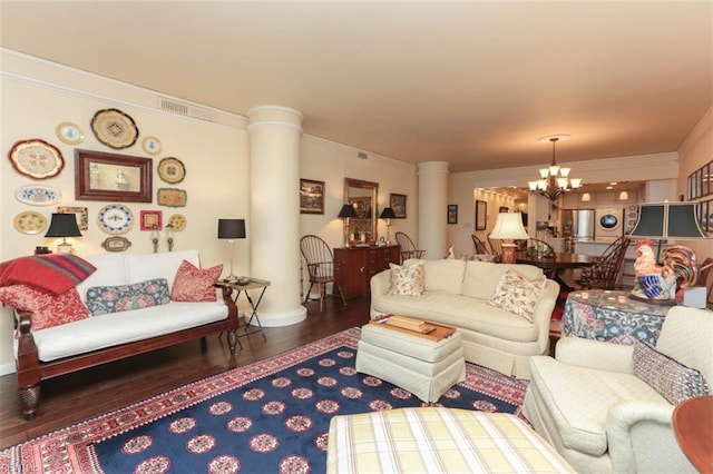 living room with decorative columns, ornamental molding, dark wood-type flooring, and a chandelier