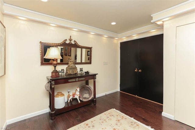 entryway with dark wood-type flooring and ornamental molding